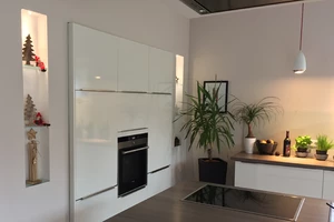 Auf dem Bild bewundern Sie eine lichtdurchflutete, offene Küche. Der eingekofferte Küchenblock und eingelassene Nischen, die ein besonderes Highlight sind und Platz für Ihre persönlichen Accessoires und Dekorationen bieten.